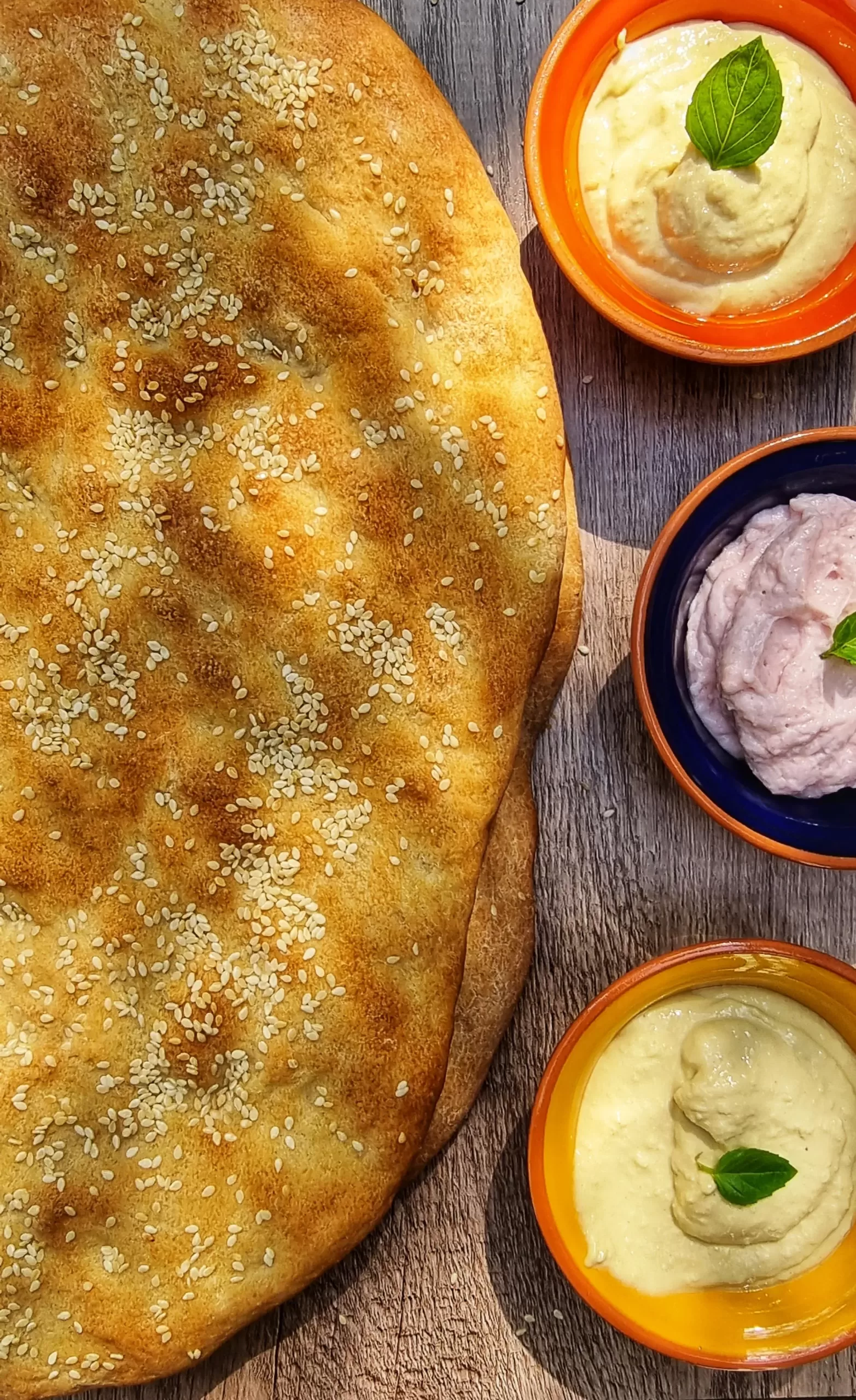 Greek lagana bread served with hummus and taramosalata