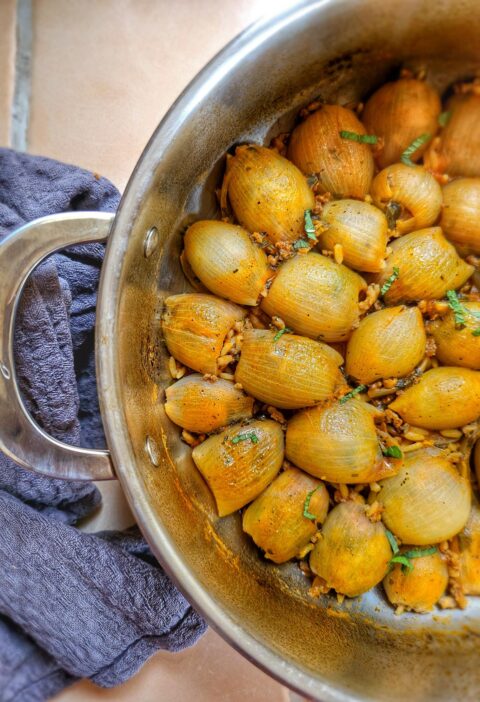 pan filled with huice, yummy greek onions stuffed with minced meat